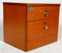 A pair of vintage 20th Century teak wood bedside cabinets with graduated drawers and brass handles