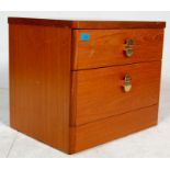 A pair of vintage 20th Century teak wood bedside cabinets with graduated drawers and brass handles