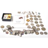 A vintage stamped sterling silver charm bracelet having various enamelled crest charms, coin charms,
