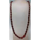 A vintage 20th Century cherry bakelite necklace having cylindrical red beads with a spring ring