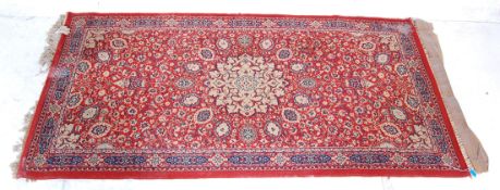 A 20th Century Persian / Islamic hall rug / carpet with a red ground featuring a central medallion