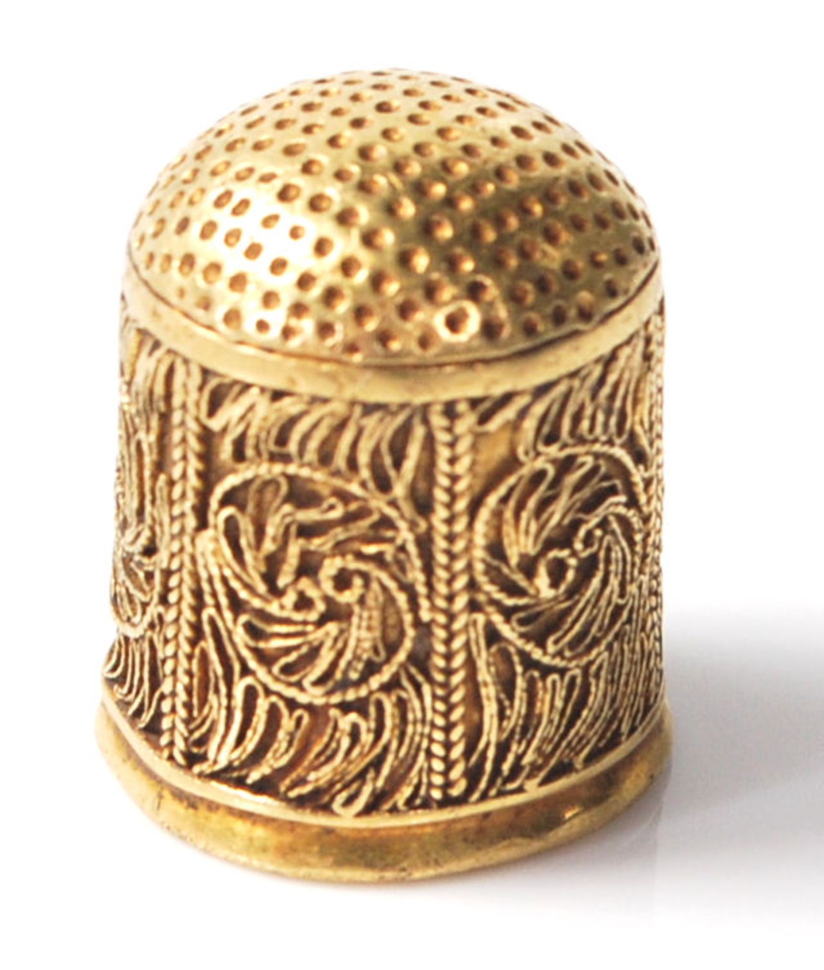 A 22ct gold thimble having filigree decoration panels to the sides. Measures 1.7cm tall. Weight 4.