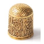 A 22ct gold thimble having filigree decoration panels to the sides. Measures 1.7cm tall. Weight 4.