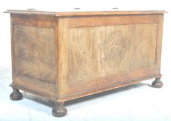 An early 20th Century oak blanket box chest / coffer having a flared and hinged top over crested