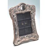 A antique white metal silver photo frame having floral decoration to the margin. Measures: 20cm