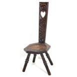 A 19th Victorian welsh oak spinning chair having an ornately carved back with pierced heart to the