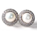 A pair of stamped .925 ladies dress earrings having a pearl set within a halo of CZ stones. Weighs