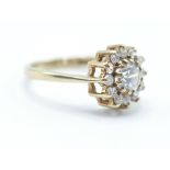 A hallmarked 9ct gold white stone cluster ring being set with a central round cut white stone and