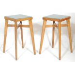A pair of vintage retro 20th Century industrial beech wood framed stools having green faux leather