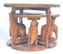 A vintage 20th Century African tribal carved wooden nest of tables having a carved top depicting a