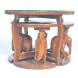 A vintage 20th Century African tribal carved wooden nest of tables having a carved top depicting a