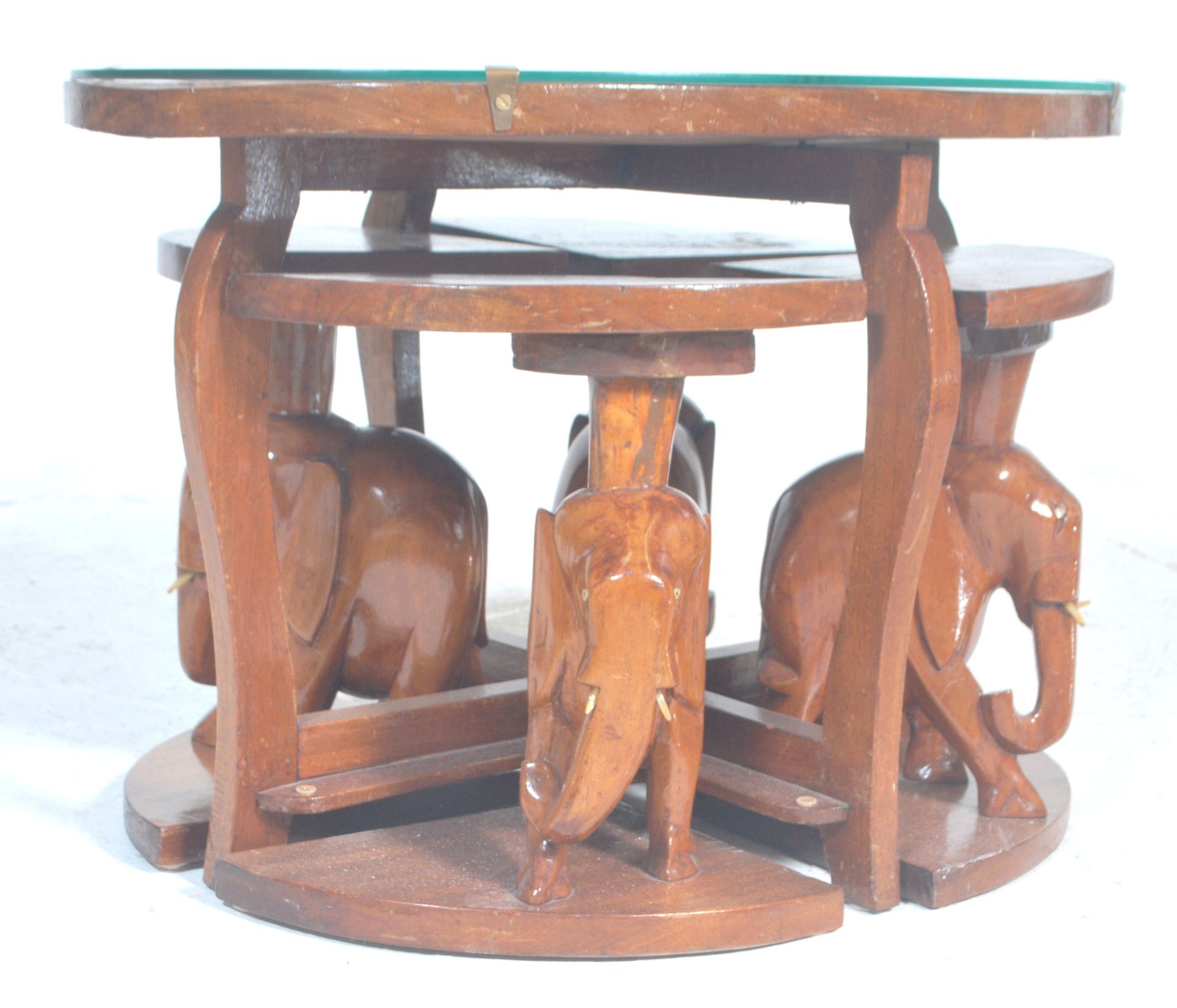 A vintage 20th Century African tribal carved wooden nest of tables having a carved top depicting a