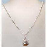 A silver pendant necklace with a revolving tiger eye stone cased in silver with a pierced frame on a