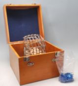 A vintage bingo game in a wooden case complete with bingo tickets, wood balls and bingo balls