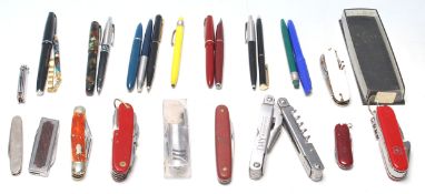 A good collection of writing pens and a Swiss penknife to include Parker pen, ball pen, fountain