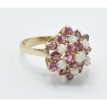 A hallmarked 9ct gold red stone and opal cluster ring having a cluster of round stones to the