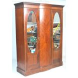 An Edwardian 20th Century large triple wardrobe compactum with bow front and quarter panel