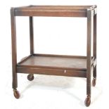 A 1930's / 1930's oak folding tea / drinks trolley having two tiers of removable trays with carved