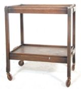 A 1930's / 1930's oak folding tea / drinks trolley having two tiers of removable trays with carved