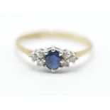 A hallmarked 9ct gold ring having a central oval cut blue stone flanked by six white accent