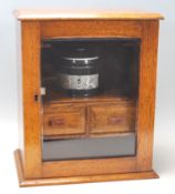 A late 19th century Victorian Art and Crafts oak smokers cabinet having a chamfered top over a