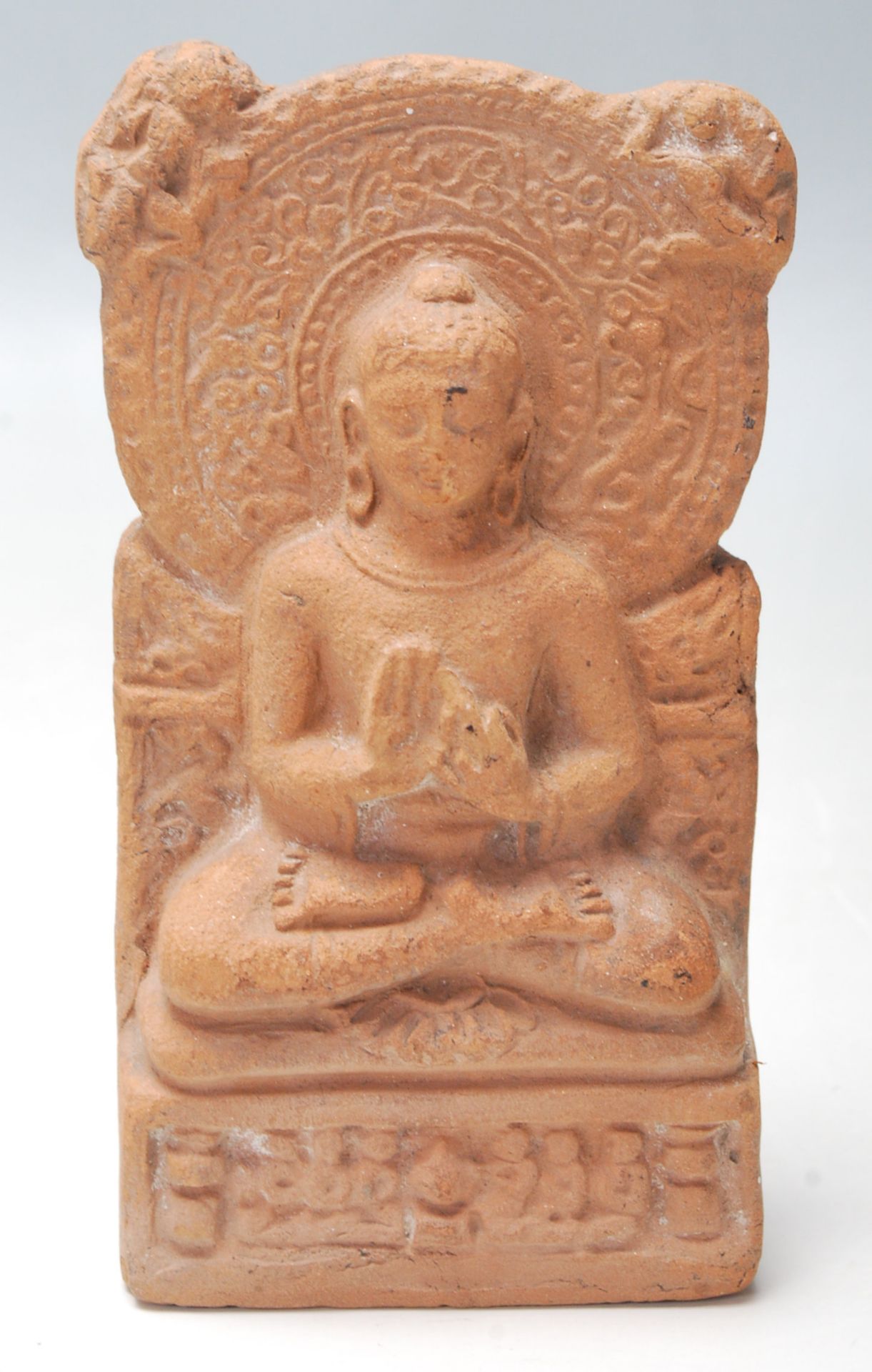 An antique 19th Century Indian terracotta buddha seated in the lotus position. The buddha having