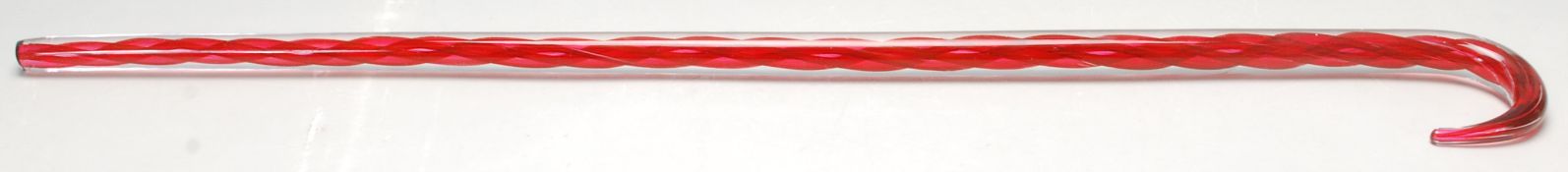 A 19th Century Victorian Nailsea cranberry glass walking stick of spiral twist design having a crook