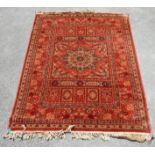 A vintage Persian Islamic rug carpet having a red background with a central star motif surround by