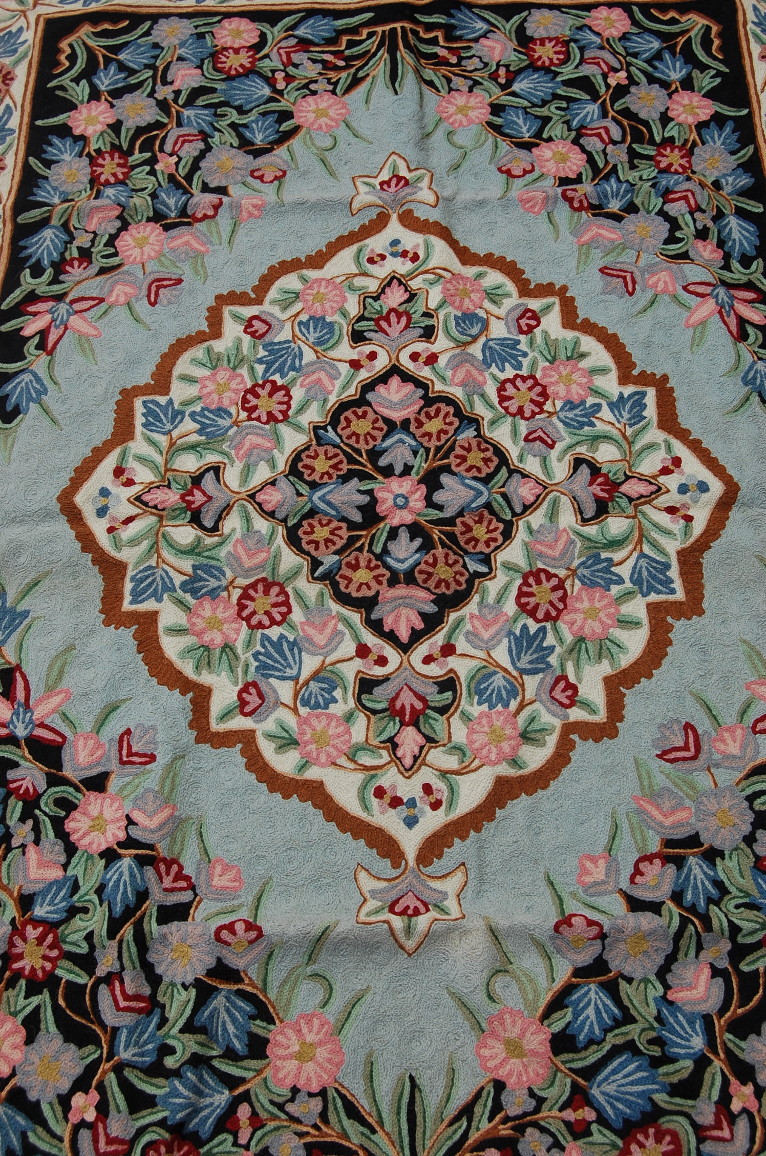 A 20th Century crewel work embroidery wall hanging having a floral bordered design around a - Image 3 of 5