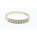 A 9ct gold ring set with nine round cut diamonds in channel settings. Assay marked for London.