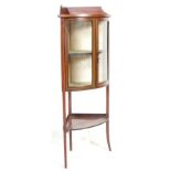 An early 20th Century Edwardian mahogany corner display cabinet having a gallery top with glazed bow