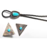 A silver white metal and leather Native American Navajo made bolo tie having a large turquoise