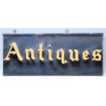 A vintage mid 20th century double side “ Antiques “ Shop advertising sign having gold letters on