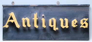 A vintage mid 20th century double side “ Antiques “ Shop advertising sign having gold letters on