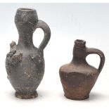 Two antique 16th Century style stoneware hand modelled jugs to to include an oil jug with applied