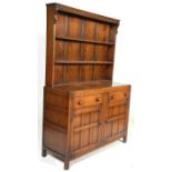 A 20th Century Old Charm style oak dresser having open fronted three open fronted shelves to the