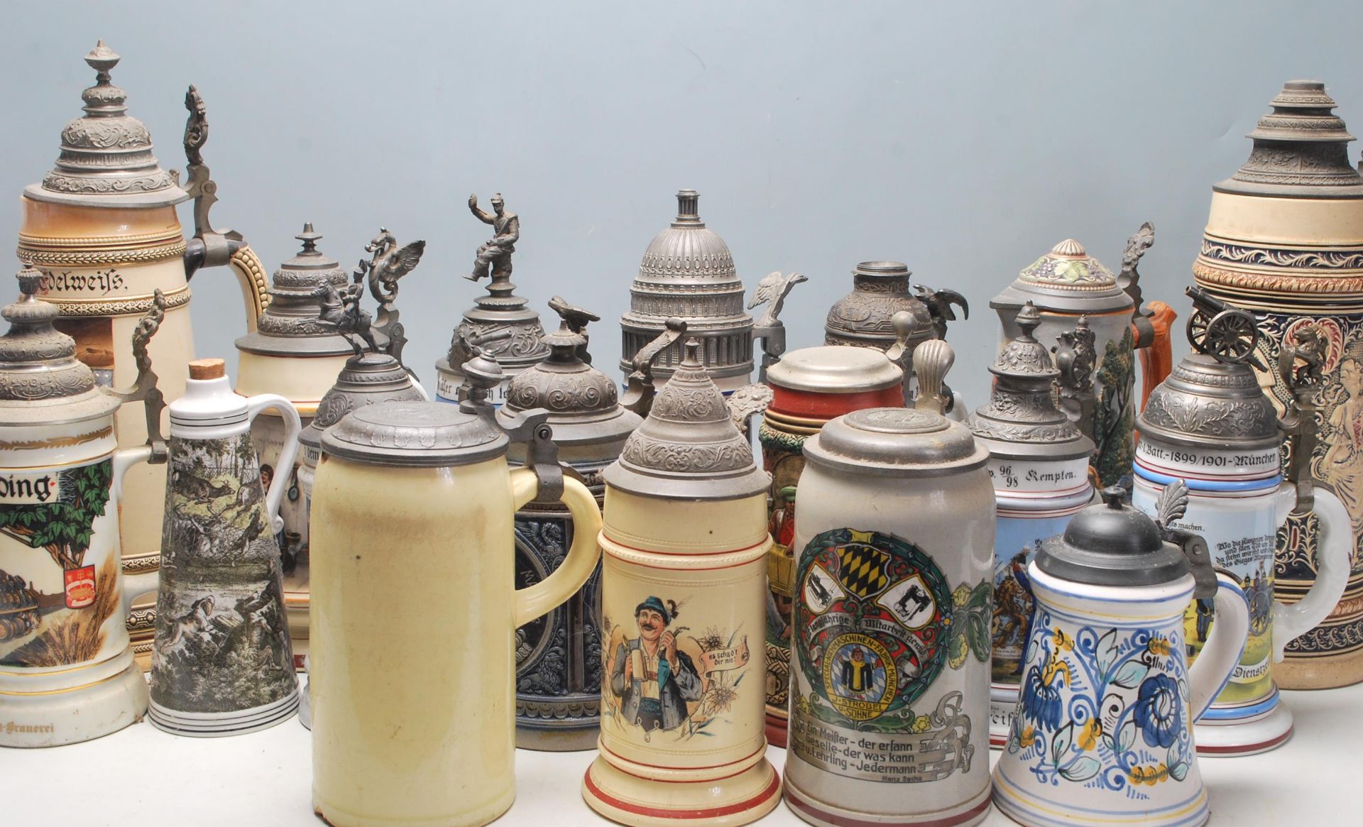 A collection of 20th Century German ceramic stein drinking glasses, each having raised polychrome