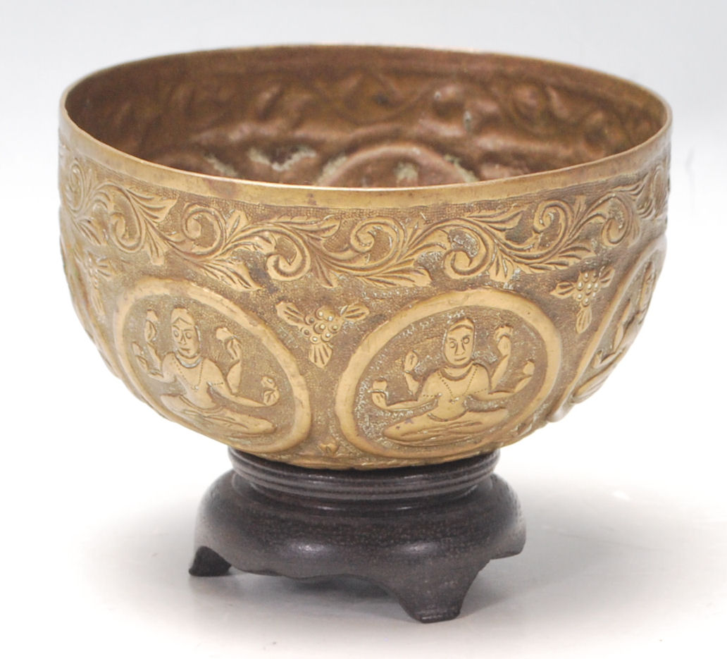 An antique Middle Eastern brass prayer bowl with hand-carved religious figurine to the centre,