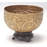 An antique Middle Eastern brass prayer bowl with hand-carved religious figurine to the centre,