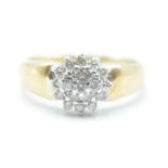 A stamped 18ct gold ring having a tapering band with a cluster of round cut diamonds. Band marked