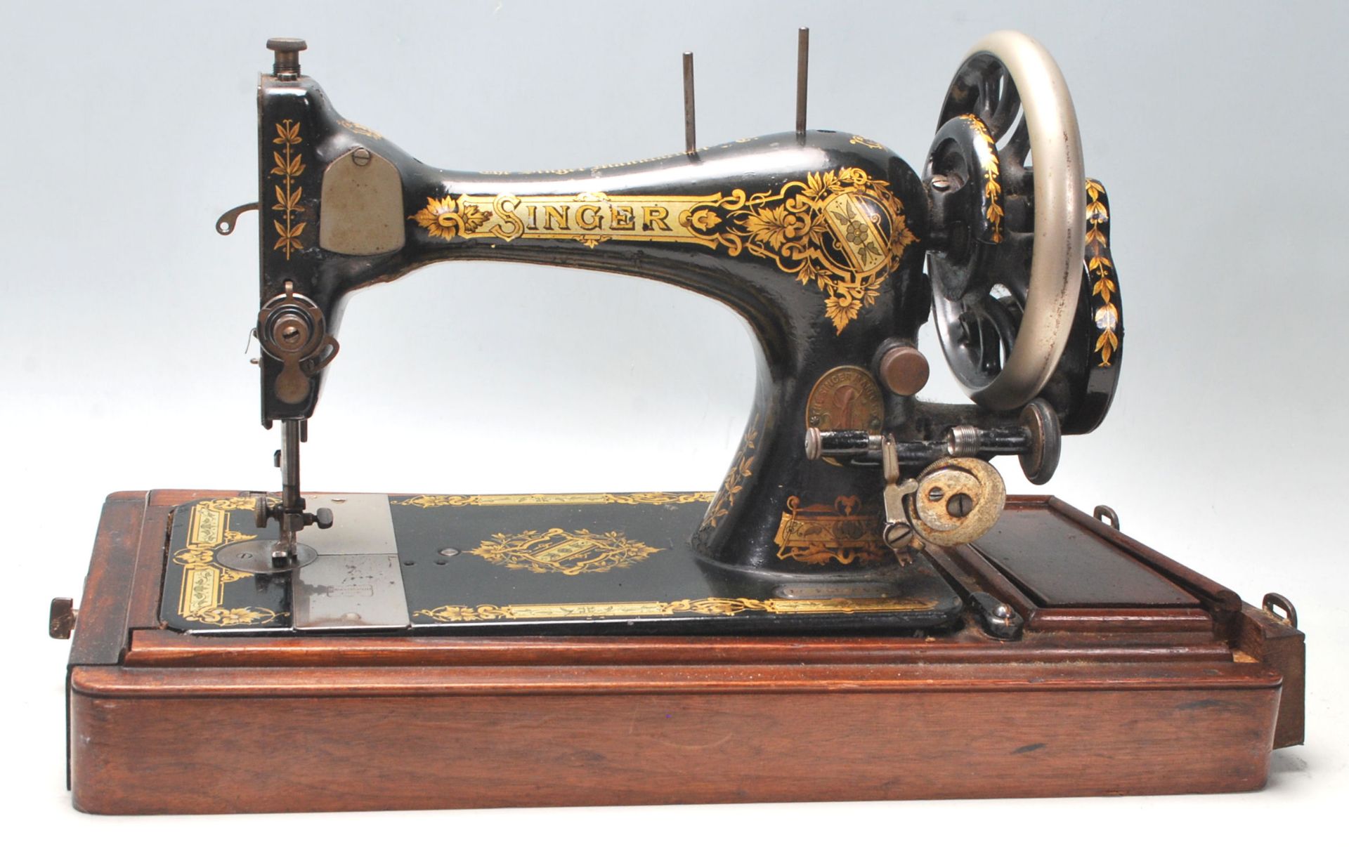 A vintage early 20th Century oak cased Singer Sewing machine having a good art deco sarcophagus
