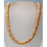 An 20th century bone carved beaded necklace having circular beads with incised decoration to each