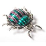 A stamped .925 silver ladies brooch in the form of an insect with green decoration to its body.