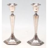 A pair of 20th Century 1920's silver hallmarked candlesticks having hexagonal bases with tapering
