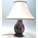 A 20th Century Moorcroft finches pattern table lamp of baluster form being decorated with tube lined