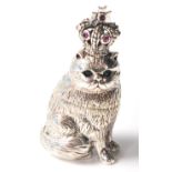 A sterling silver figurine of a cat wearing a crown having eyes and crown inset with stones.