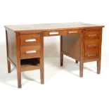 A retro vintage mid century oak air ministry twin pedestal office desk having a wooden top with pull