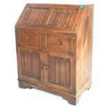 A Jacobean revival 1930's oak bureau decorated wit