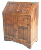 A Jacobean revival 1930's oak bureau decorated wit