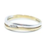 A hallmarked 9ct gold two tone split band ring set with three round cut diamonds. Hallmarked